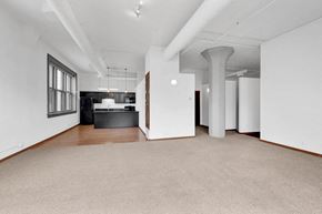 Omaha apartment for rent - an empty living room with a kitchen in the corner