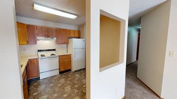 Sioux Falls apartment for rent - A kitchen with wooden cabinets and a white refrigerator.