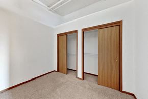 Omaha apartment for rent - a bedroom with two closets and a carpeted floor