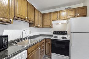 Des Moines apartment for rent - a kitchen with white appliances and wooden cabinets