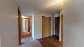 Sioux Falls apartment for rent - A hallway with a light on the ceiling and a carpet on the floor.