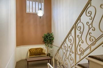 Des Moines apartment for rent - a living room with a gold couch and a staircase