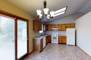 Sioux Falls townhouse for rent - A kitchen with wooden cabinets and white appliances.
