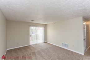 Plattsmouth apartment for rent - an empty living room with a door to a balcony