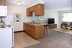 Grand Forks apartment for rent - A kitchen with a white stove top oven and wooden cabinets.