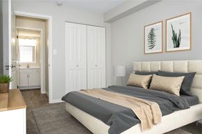 Grand Forks apartment for rent - A bedroom with a large bed and two framed pictures on the wall.