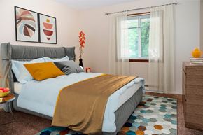 Grand Forks apartment for rent - A bedroom with a bed, a nightstand, and a window with curtains.