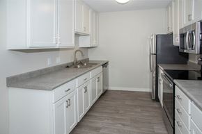 Grand Forks apartment for rent - A kitchen with white cabinets and a grey countertop.