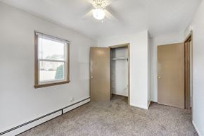 Urbandale apartment for rent - a bedroom with a closet and a window and a ceiling fan