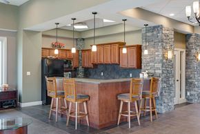 Kansas City townhouse for rent - a kitchen with a bar with chairs and a stone wall