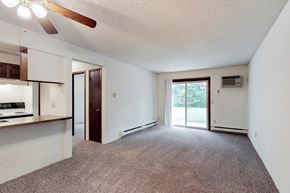 Des Moines apartment for rent - an empty living room with a kitchen and a sliding glass door