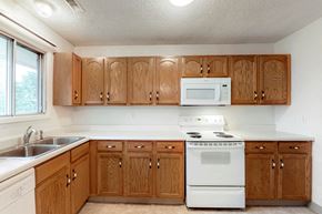 West Des Moines apartment for rent - a kitchen with white appliances and wooden cabinets