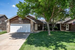 Sioux Falls townhouse for rent - A house with a garage and a tree in front.
