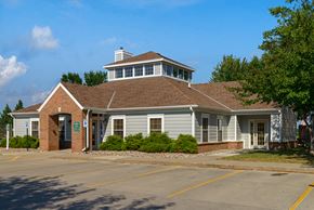 Norwalk apartment for rent - a white building with a brown roof and a parking lot
