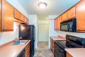Des Moines apartment for rent - a kitchen with black appliances and wooden cabinets