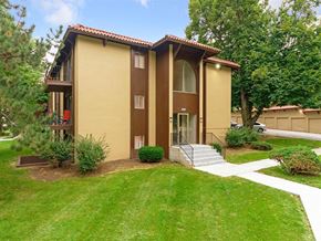 Omaha apartment for rent - a yellow house with a yard and stairs