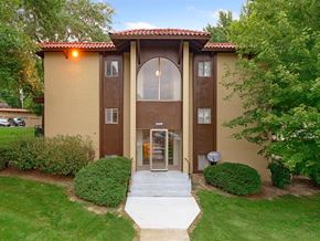 Omaha apartment for rent - the front entrance of a building with a walkway and trees