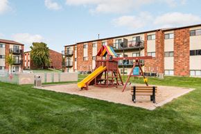 Sioux Falls apartment for rent - A playground with a yellow slide and a red and yellow structure.