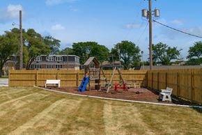 Urbandale apartment for rent - a playground with a swing set in a fenced in yard