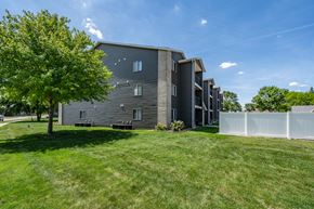 Sioux Falls apartment for rent - A modern building with a white fence in front.
