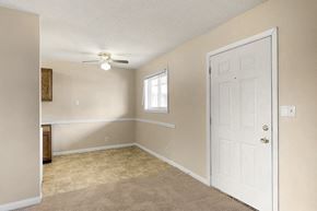 Davenport apartment for rent - an empty living room with a white door and a window