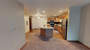Sioux Falls apartment for rent - A kitchen with a refrigerator, sink, and cabinets.