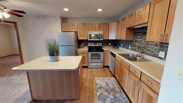 Sioux Falls apartment for rent - A kitchen with wooden cabinets and a white island.