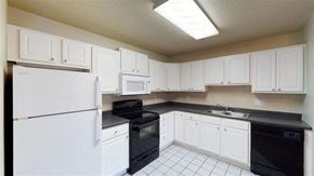 Sioux Falls apartment for rent - A kitchen with white cabinets and black appliances.