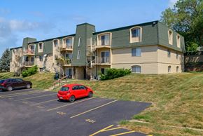 Urbandale apartment for rent - a car parked in a parking lot in front of an apartment building