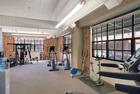 Omaha apartment for rent - a gym with exercise equipment and windows in a loft