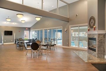 Omaha apartment for rent - a large living room with a fireplace and a table and chairs
