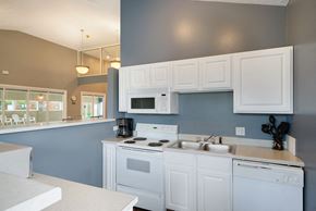 Omaha apartment for rent - a kitchen with white cabinets and a sink and a stove