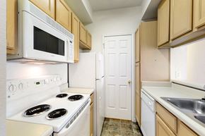 Norwalk apartment for rent - a kitchen with white appliances and wooden cabinets