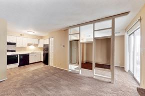 Omaha apartment for rent - an empty living room with a kitchen and sliding glass doors