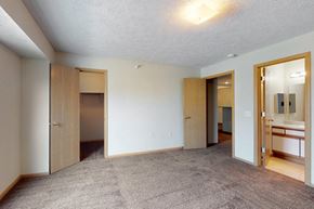 Omaha apartment for rent - a bedroom with a carpeted floor and a bathroom with mirrors