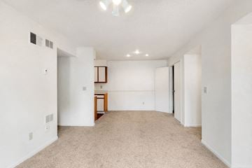 Kansas City apartment for rent - the living room and dining room of an apartment with white walls and carpet