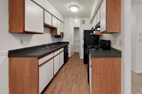 Kansas City apartment for rent - a kitchen with black counter tops and wood flooring and