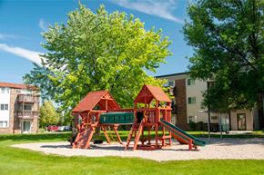 Grand Forks apartment for rent - a playground in the middle of a yard with trees and apartment buildings