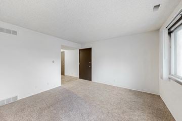 West Des Moines apartment for rent - the spacious living room and dining room of an apartment with white walls and carpet