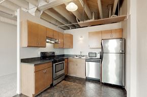 Omaha apartment for rent - a kitchen with stainless steel appliances and wooden cabinets