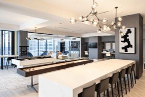 Indianapolis apartment for rent - a communal table with a shuffleboard and foosball table at 220 Meridian, Indianapolis, IN 46204