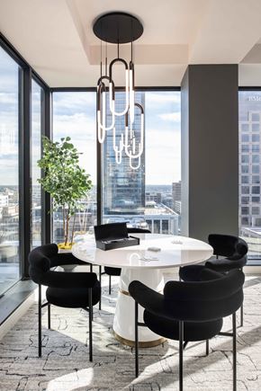 Indianapolis apartment for rent - a round white table with black chairs in a room with floor to ceiling windows  at 220 Meridian, Indianapolis, IN, 46204
