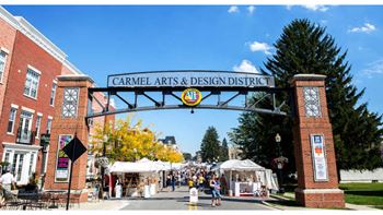 A street view of the carmel arts & design district with people walking and stalls set up.