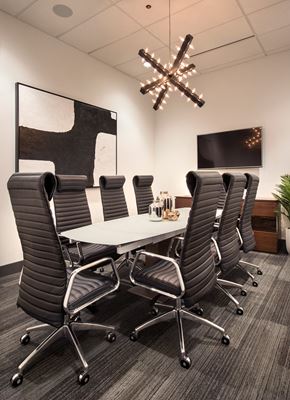 Carmel apartment for rent - A conference room with a large table surrounded by chairs and a chandelier hanging from the ceiling at The Olivia Apartments, Carmel, IN, 46032