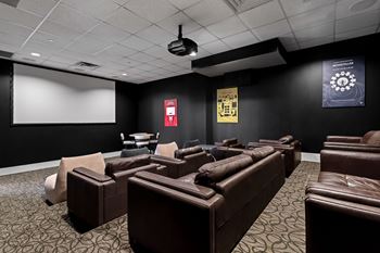 A dark room with a screen and chairs.
