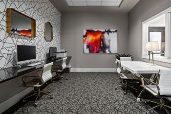 A room with a patterned wallpaper and a large abstract painting on the wall.