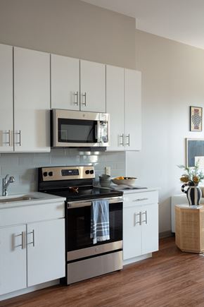 Kansas City apartment for rent - a white kitchen with stainless steel appliances and a microwave