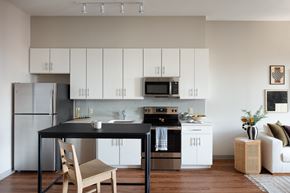 Kansas City apartment for rent - a kitchen with white cabinets and a black counter top