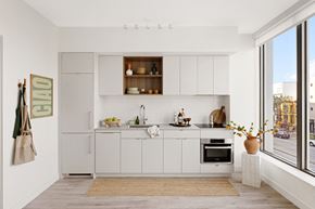 Washington apartment for rent - a small kitchen with white cabinets and a large window