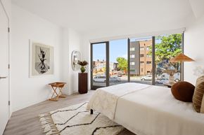 Washington apartment for rent - a bedroom with a bed and a large window